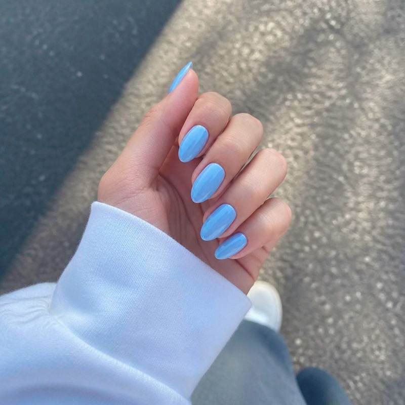 Фотография глянцевого маникюра в оттенке baby blue на длинных миндалевидных ногтях